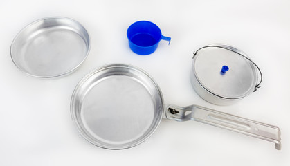 Aluminum cooking utensils from camping mess kit on a white background. Horizontal.