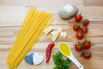 Pomodori formaggio grana sale olio per una buonissima preparazione del sugo con la pasta su tavolo di legno 