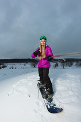 Young woman with the snowboard shooting a selfie by her action camera