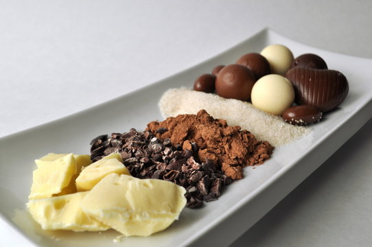 Cacao butter, beans, powder, sugar and chocolates with copy space
