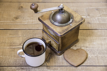 Manual vintage coffee grinder, cup of coffee and ginger biscuits