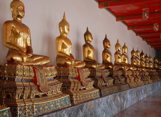 Buddhas at Wat Pho long gallery. The temple was built in XII century in Bangkok, Thailand 