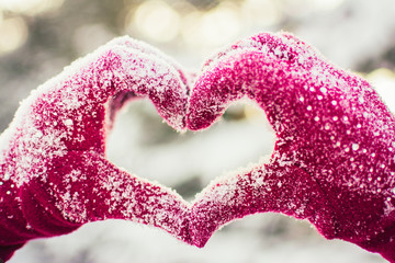 Women's hands in gloves in the shape of Heart