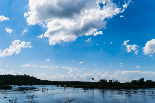 Panorama of the Iguazu Waterfalls in Argentina and Brazil with cloudy blue sky