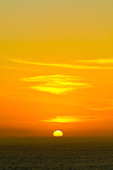 Sunset over the ocean with yellow sky at Arraial do Cabo, Rio de Janeiro, Brazil