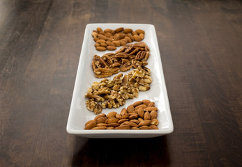 Arranged Pecans, Walnuts, and Almonds on White Tray, perspective