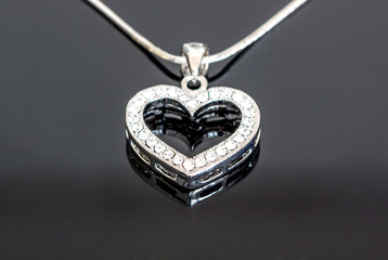 silver jewelry / necklaces with heart pendants on black background / necklaces with heart pendants for woman