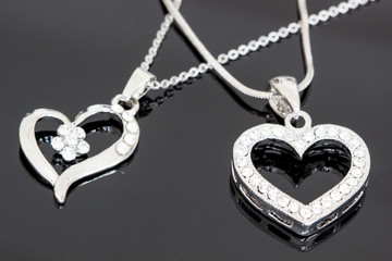 silver jewelry / necklaces with heart pendants on black background / necklaces with heart pendants for woman