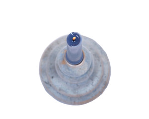 Blue clay ceramic candle holder and blue candle isolated on white background
