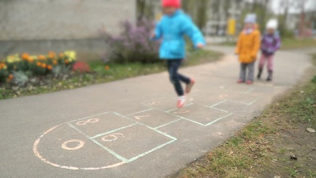 Little girls playing hopscotch outdoors