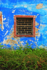 Zakratowane okno w niebieskiej ścianie