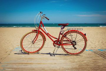 Retro red bicycle on beautiful beach background