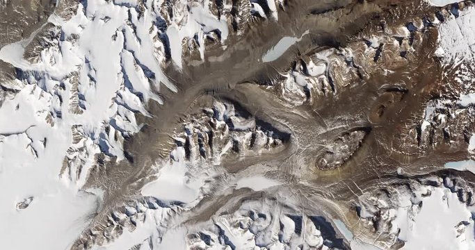 High-altitude overflight aerial of rock outcrops and bare valleys around Taylor Glacier, Antarctica. Clip loops and is reversible. Elements of this image furnished by USGS/NASA Landsat