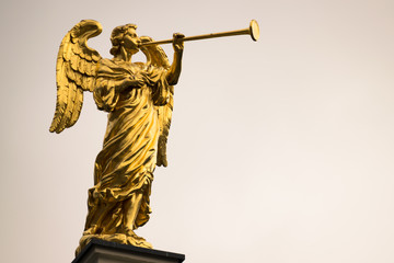 Golden angel with a trumpet and copy space. - obrazy, fototapety, plakaty