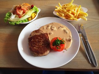 Beef hamburger steak with mushroom sauce and baked tomato set