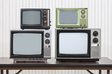 Four Vintage Televisions Stacked on Table