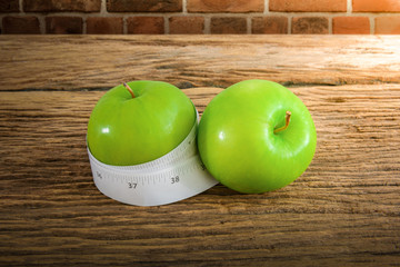 Measuring tape wrapped around a green apple