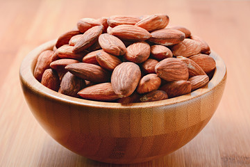 Closeup almonds in wooden bowl