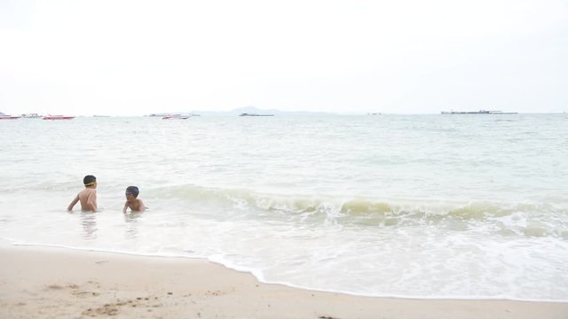 young Asian Thai boy playing on the sand beach