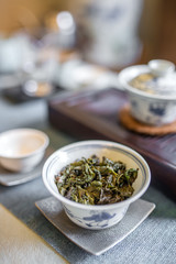 Chinese tea ceremony. Traditional cup with green tea leaves insi