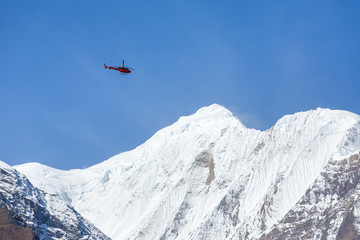 Fototapeta na wymiar Rescue helicopter in high Himalayan mountains. Annapurna Range 