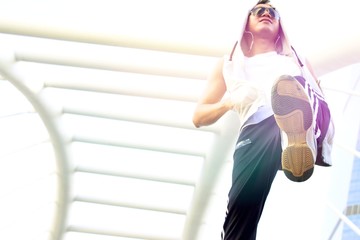 A man in sport wear is warming up his body during exercise jogging in the city.