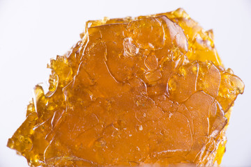 Cannabis oil concentrate aka shatter isolated over white backgro