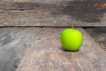 Green apple on wooden table  background