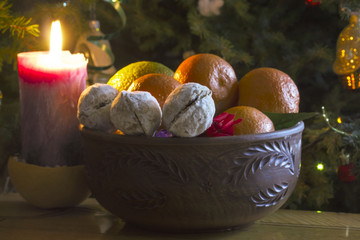 sweet with ripe tangerines near burning candle on a table