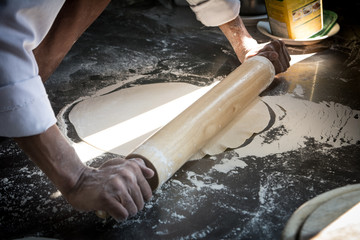 Hands preparing a pizza  (dark background)