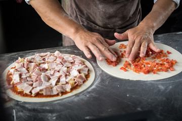 Hands preparing a pizza  (dark background)
