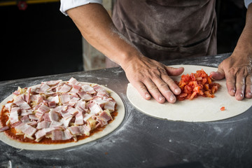 Hands preparing a pizza  (dark background)