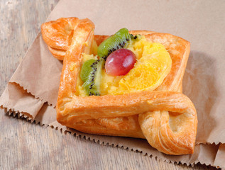 sweet bun with fruits on wooden background