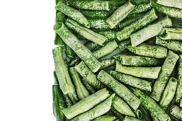 Border of fresh frozen green french bean with hoarfrost closeup on white background. Isolated. Healthy vitamin food.