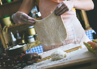 Close up of female baker hands kneading dough and making bread.