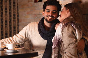 Beautiful young couple in love sitting in cafe.