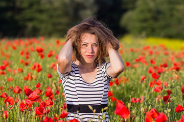 Smiling young woman on poppy field