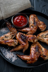 Closeup of grilled chicken wings with sesame, sea salt and sauce