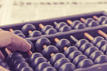 close up image of hand accounting with old abacus. financial concept