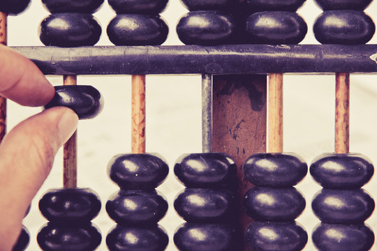 close up image of hand accounting with old abacus. financial concept