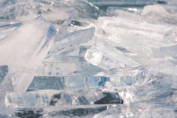 Fototapeta na wymiar Texture of ice surface, cracked ice floating on blue water, seasonal winter landscape.