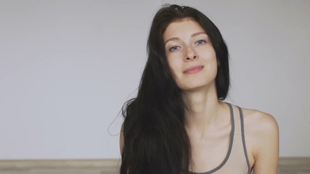 Young woman fitness and yoga spott style posing into camera and smile slomotion