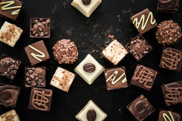 Delicious chocolate candies, truffles on the black background.