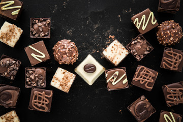 Delicious chocolate candies, truffles on the black background.
