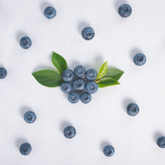 flat lay of blueberry with green leaves over white background, c