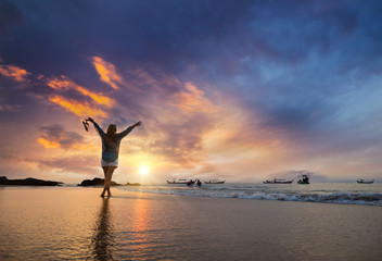 Young woman walking on a sandy beach