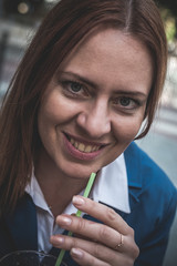 Blond young woman eating outdoor in street