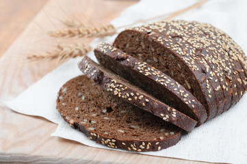 fresh rustic wholemeal rye bread, sliced on a wooden board