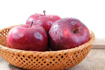 red apples in wicker basket isolated