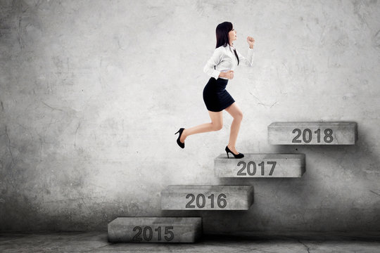 Businesswoman steps on stairs with 2017